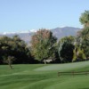 A view of a green with mountains in background at Sunset Golf Course