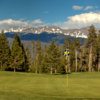 View of a green with mountains in the background from the Meadow Golf Course at Pole Creek Golf Club.